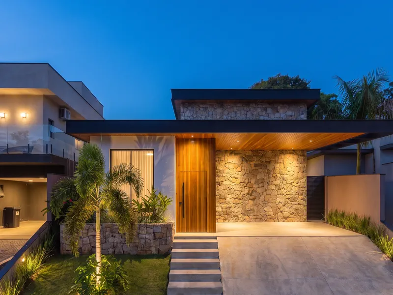 Fachada lateral da residência iluminada ao anoitecer